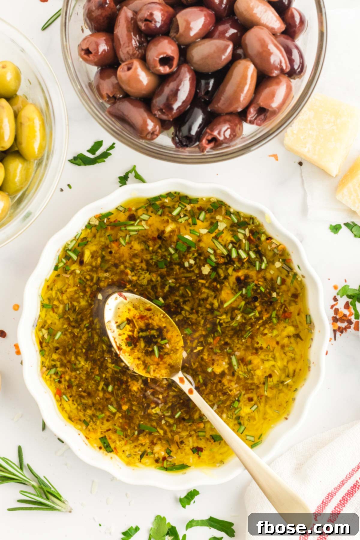 Overhead photo of a white dish with olive oil bread dip with a spoon in it.
