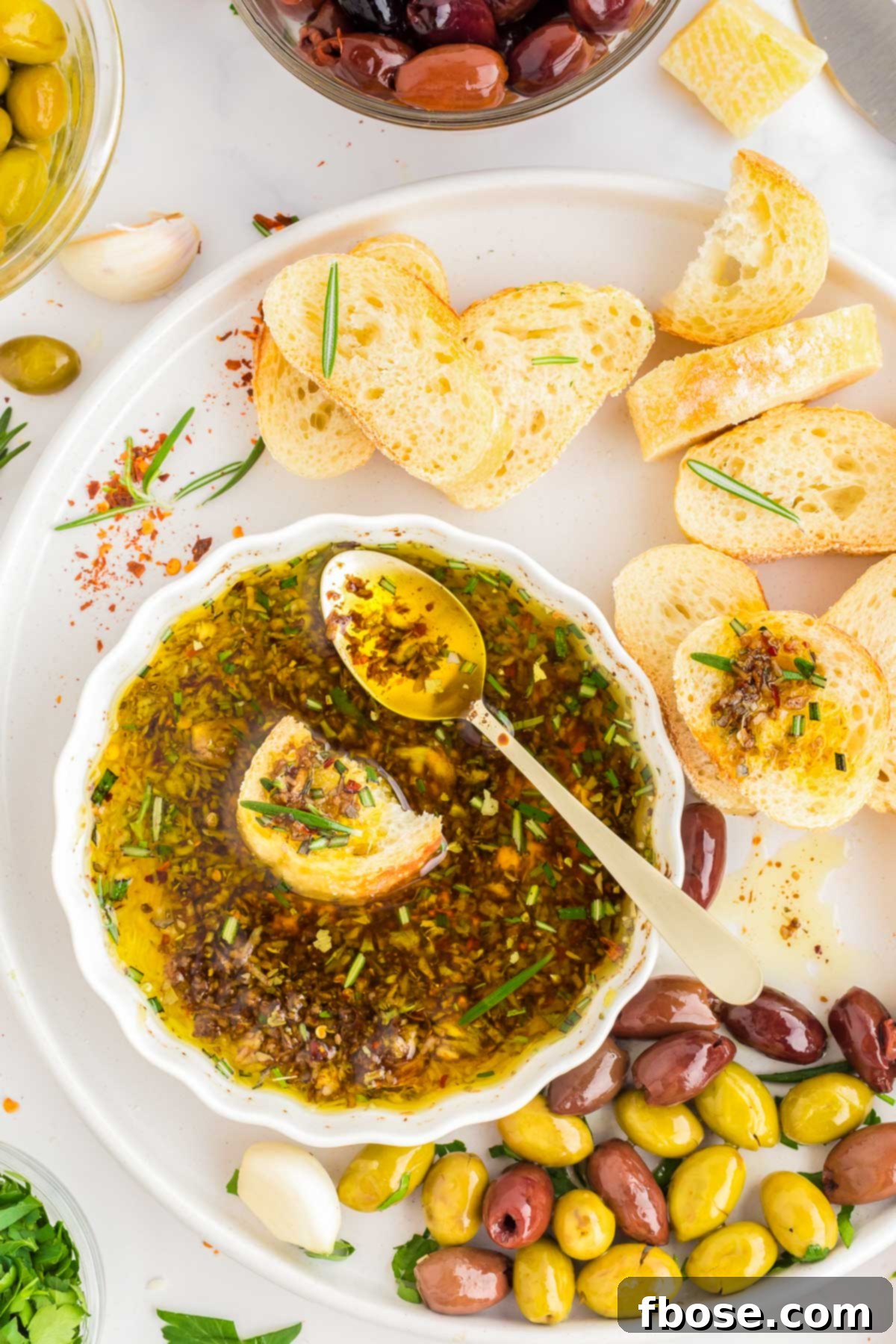 Overhead photo of bread being dipped in olive oil and spices.