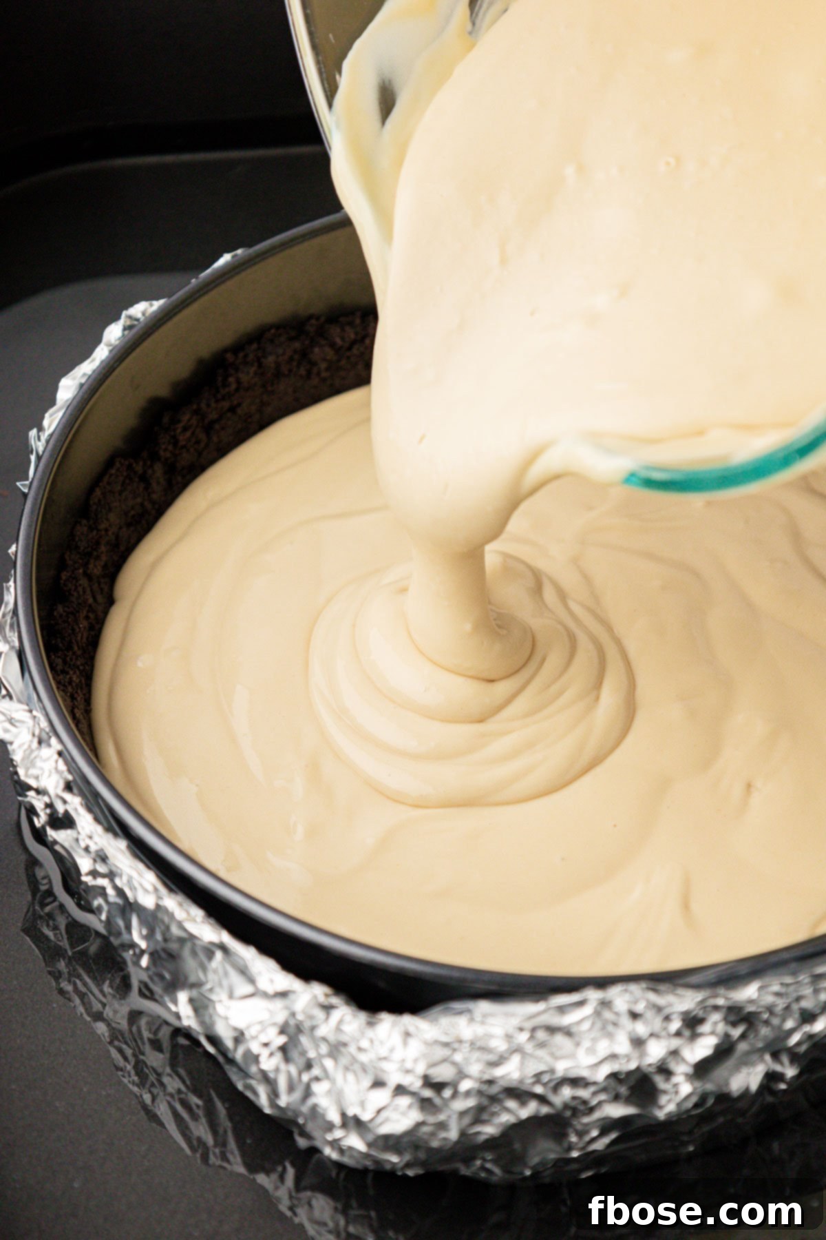 Gourmet Coffee Cheesecake 7 Coffee cheesecake filling being poured into a springform pan.
