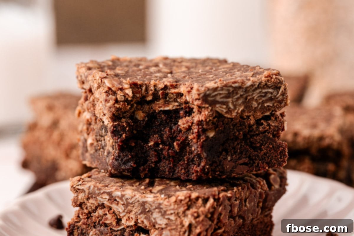 Effortless Fudgy Cookie Brownie Bars 3 No Bake Cookie Brownies stacked with the top one missing a bite.