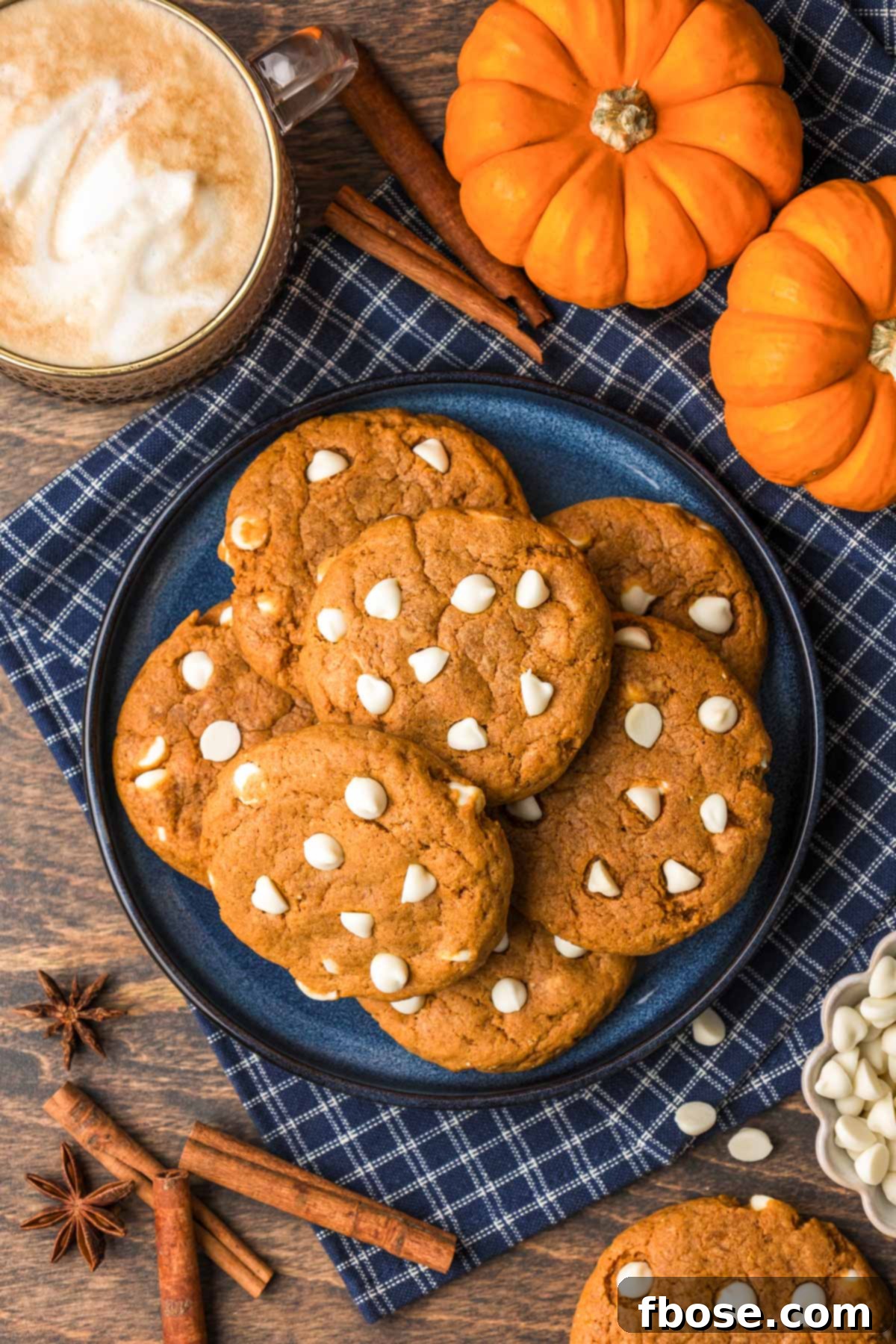 Overhead photo of pumpkin white chocolate cookies arranged on a blue plate, ready to be served.