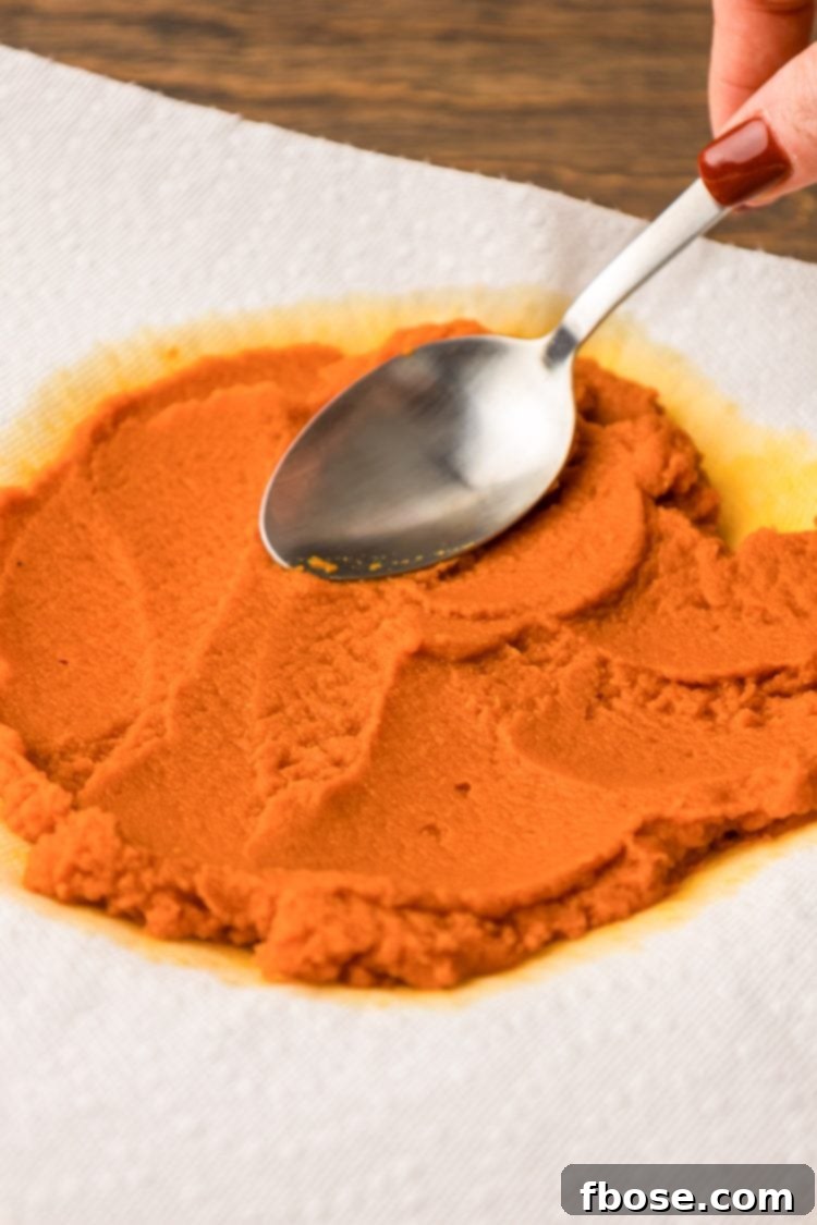 Pumpkin puree being spread out on paper towels to remove excess moisture.