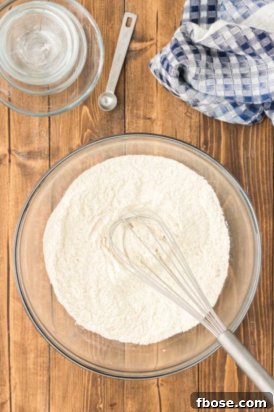 Fluffy Coin Pancakes 11 Dry ingredients being whisked together in a glass mixing bowl.