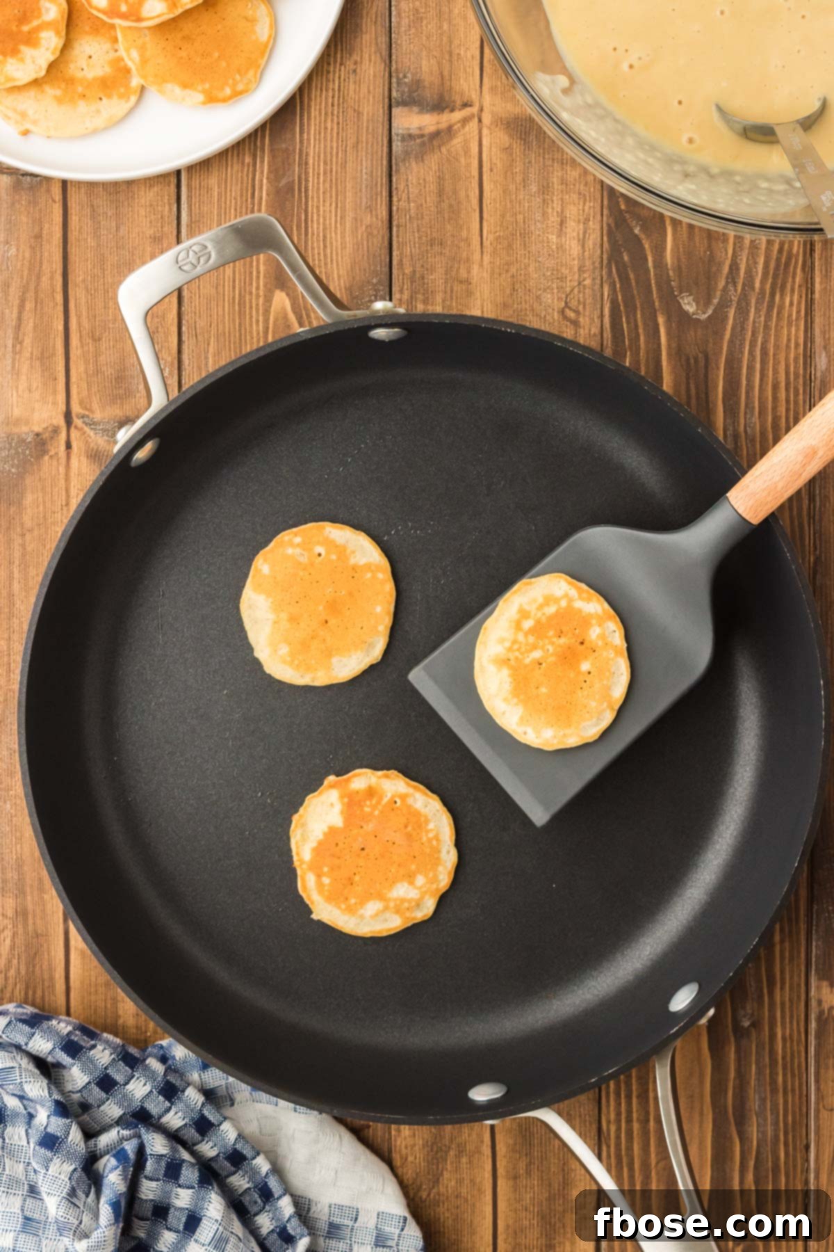 Fluffy Coin Pancakes 5 Mini pancakes sizzling and bubbling on a hot pan, showing the perfect stage for flipping.
