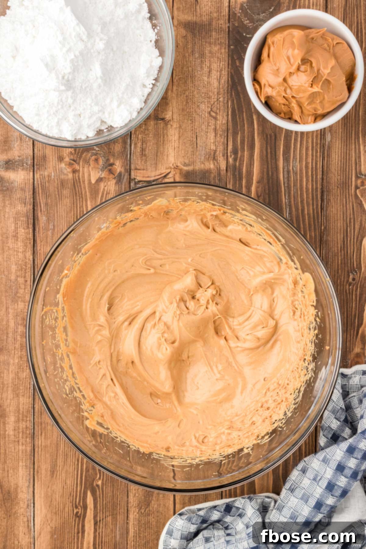 No-Bake Peanut Butter Crunch Bites 5 A glass mixing bowl holds a creamy, golden mixture of peanut butter, softened butter, and vanilla, perfectly beaten together.
