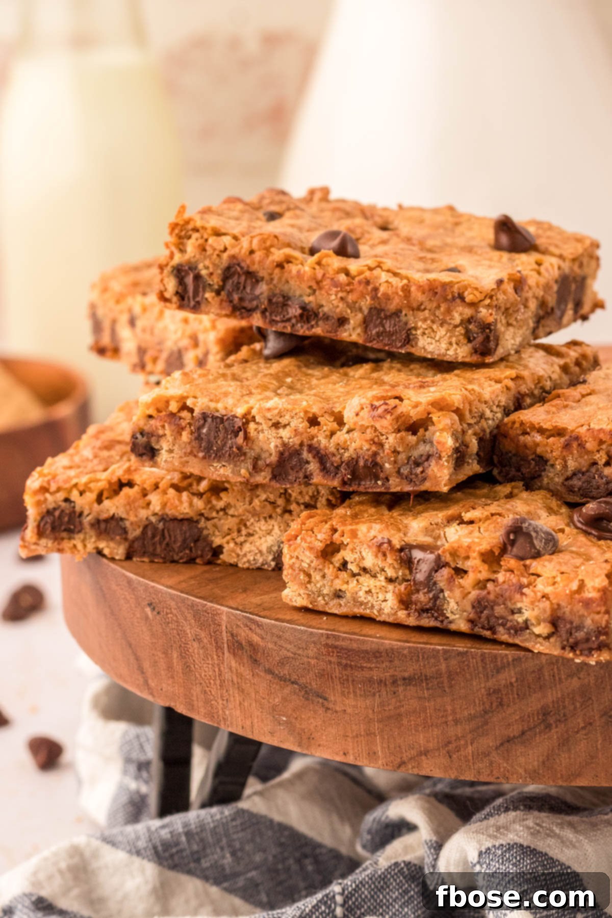 A collection of golden graham cracker chocolate chip bars arranged beautifully on a rustic wooden cake stand, highlighting their irresistible texture.
