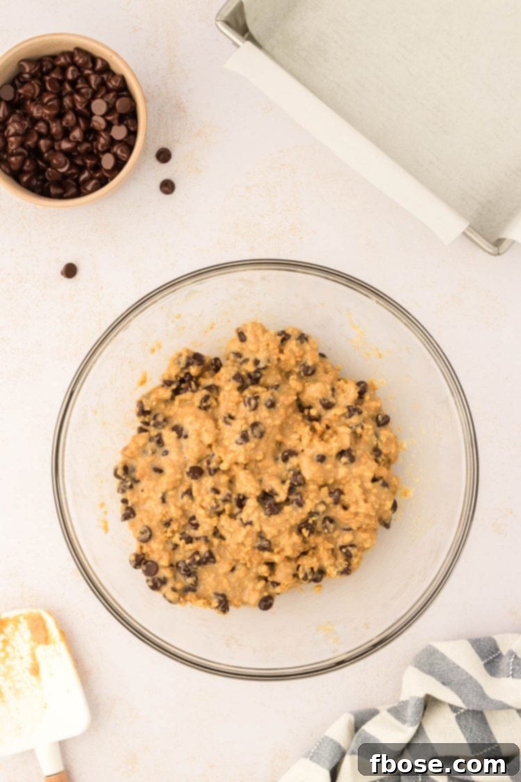 Thick, sticky graham cracker bar batter in a glass bowl, showcasing the consistency before baking.