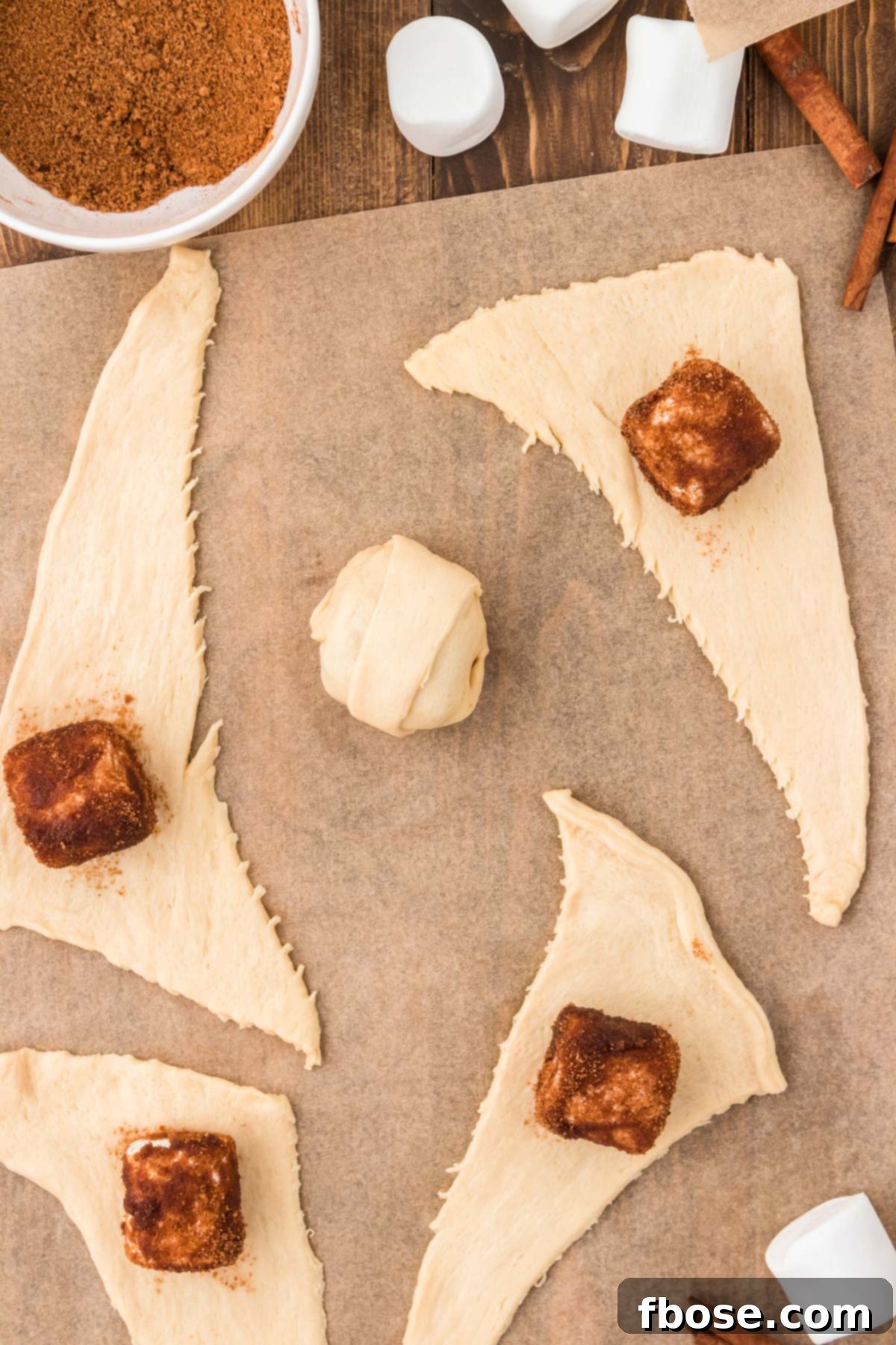 Overhead photo of resurrection rolls being made on a piece of parchment paper. 