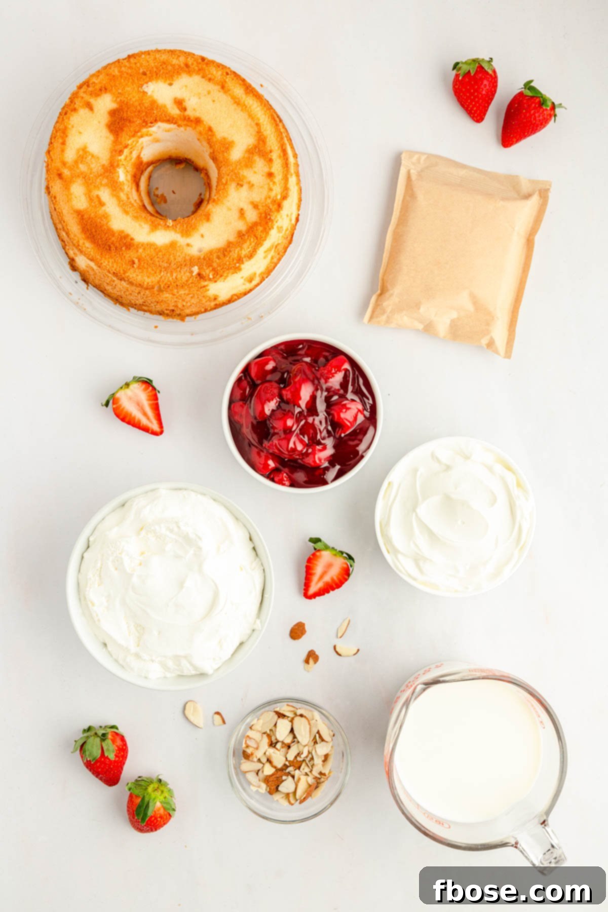 Various ingredients laid out on a white counter, ready to be assembled into strawberry Heaven on Earth cake, highlighting fresh and packaged components.