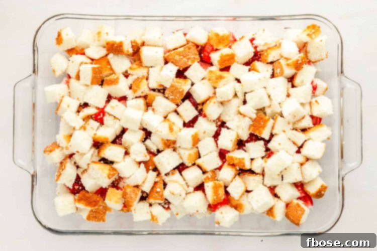 Second layer of angel food cake cubes carefully placed over the strawberry filling in a pan.