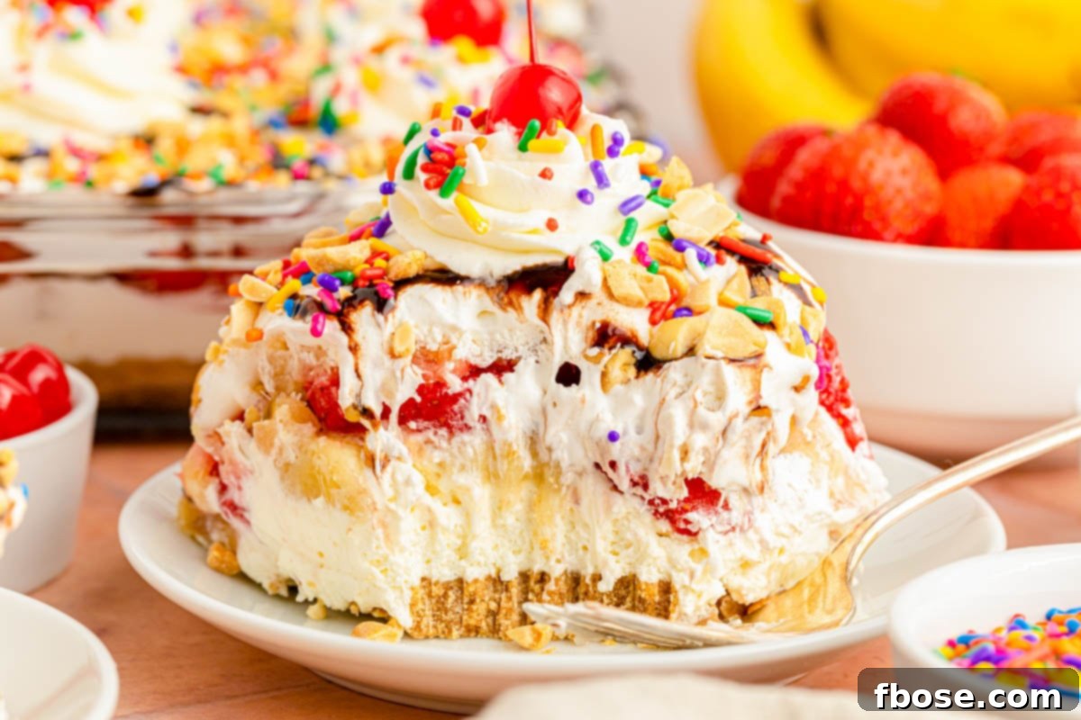 A tantalizing slice of no-bake banana split cake on a white plate, showcasing its layers and toppings, ready to be eaten.