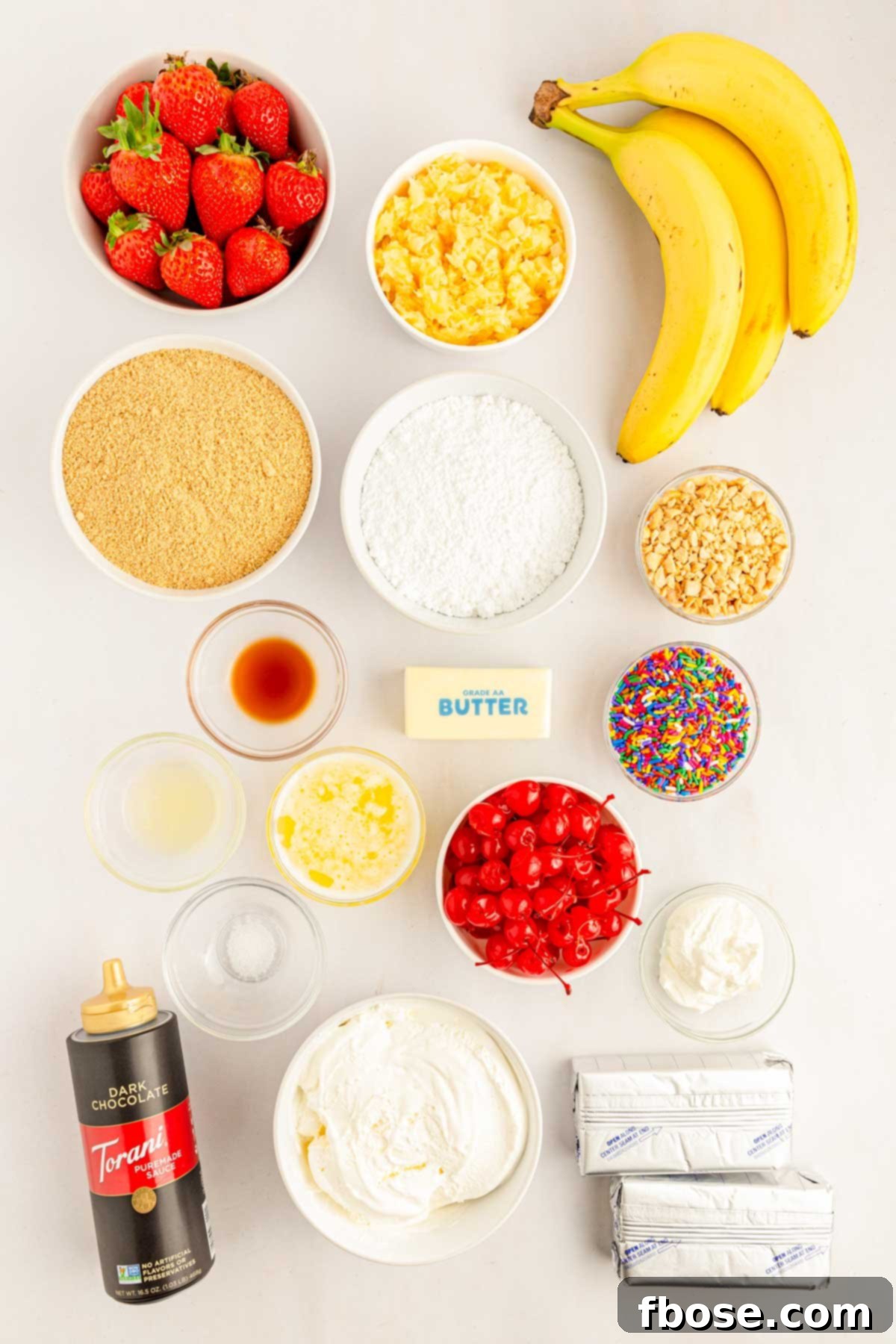 An overhead shot displaying all the fresh ingredients laid out on a table, ready to be assembled into the no-bake banana split cake.