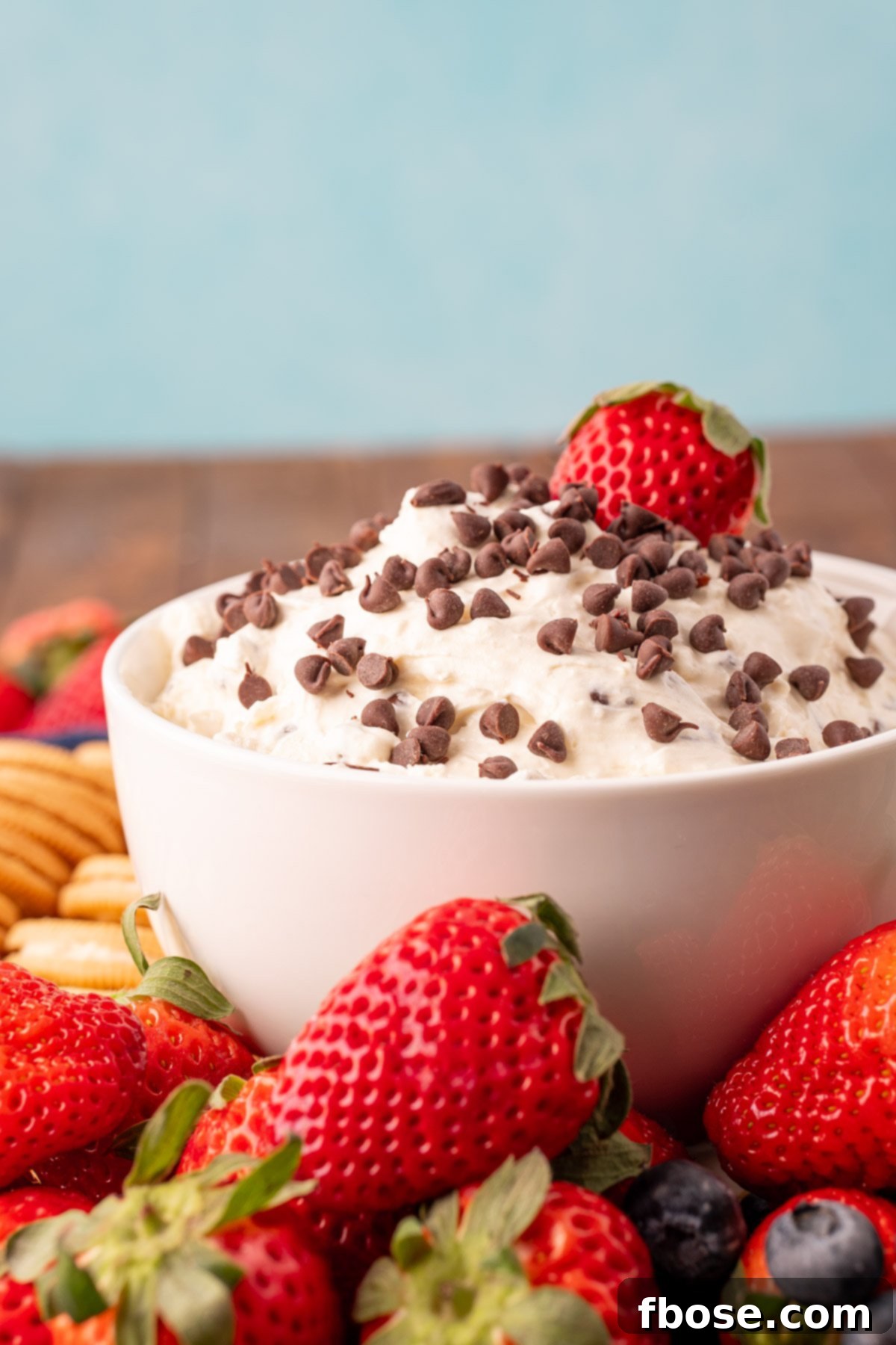 A pristine white bowl brimmed with velvety marshmallow chocolate chip Booty Dip, showcasing its smooth, creamy texture and generous scattering of mini chocolate chips, ready to be enjoyed.