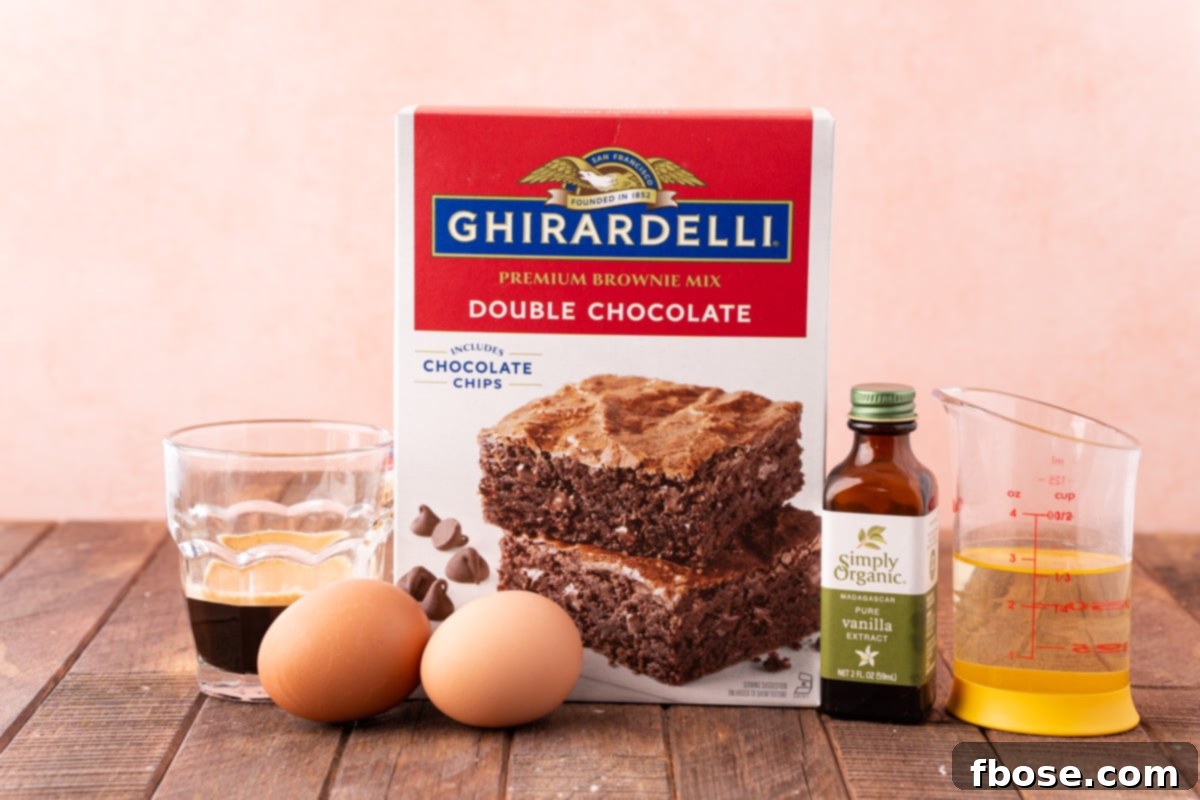 A collection of ingredients for enhanced box mix brownies, including a box of mix, eggs, oil, coffee, and vanilla, neatly arranged on a wooden table.