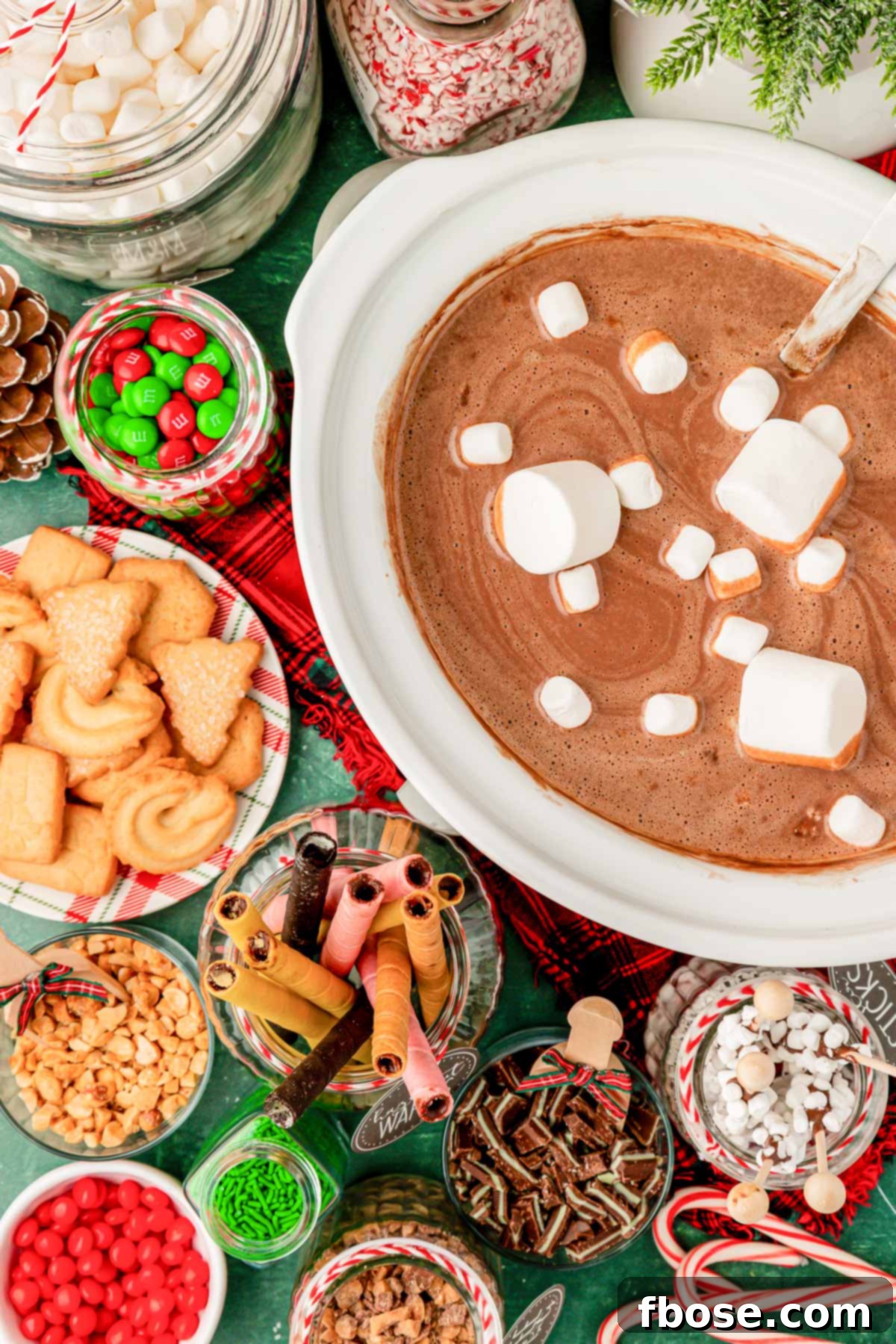 Overhead photo of a crockpot of hot chocolate with ingredients to add to it.