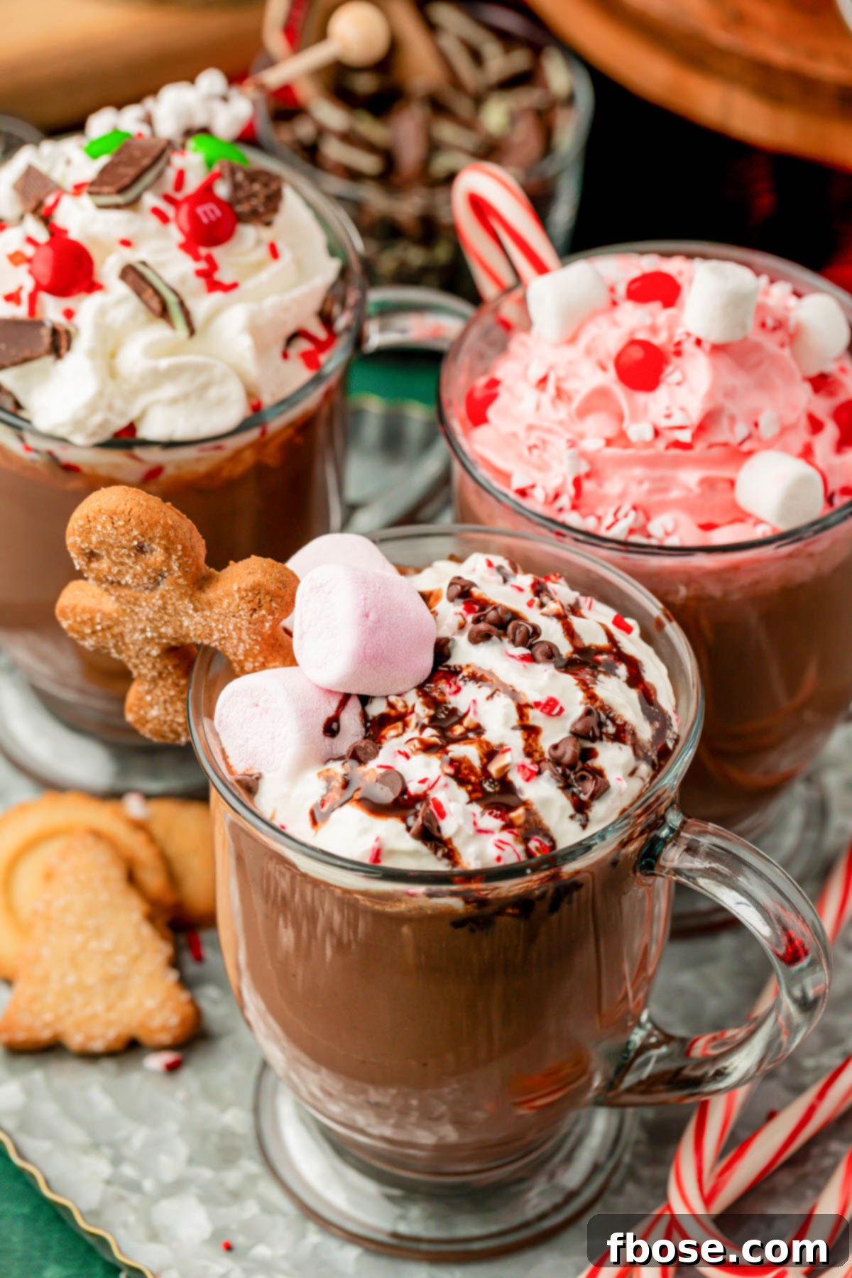 Three glass mugs of hot chocolate on a table.