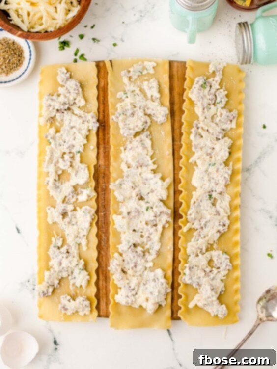 Three lasagna noodles laid flat on a cutting board, each generously spread with a creamy ricotta filling.