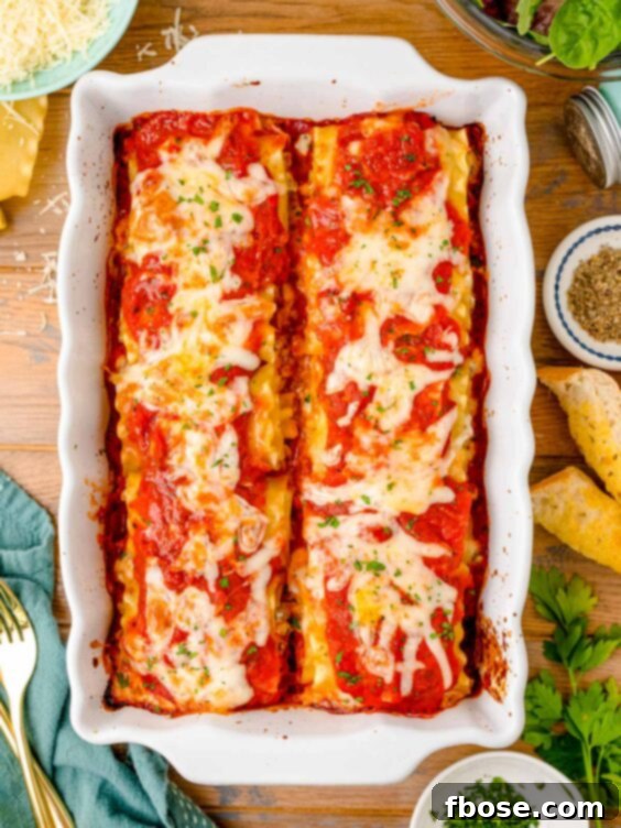 An overhead shot of bubbling hot lasagna roll-ups in a baking dish, freshly out of the oven and ready to be served.