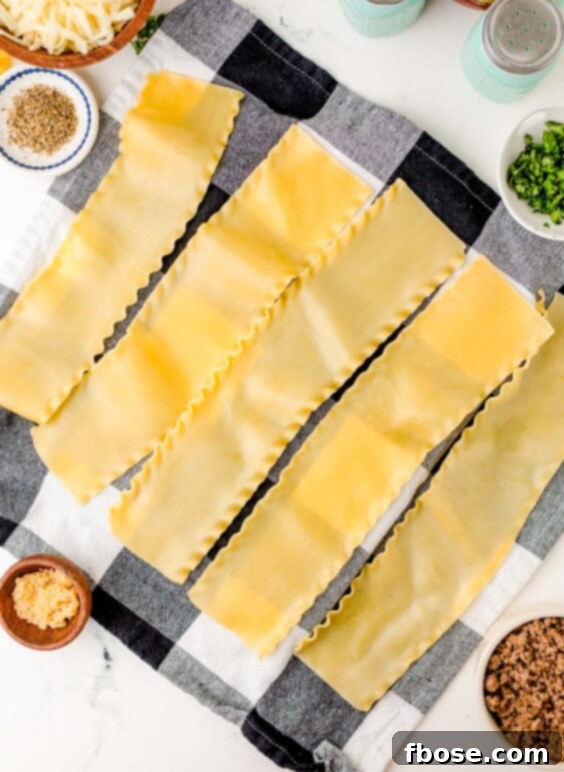 Cooked lasagna noodles laid out on a kitchen towel, ready for filling.