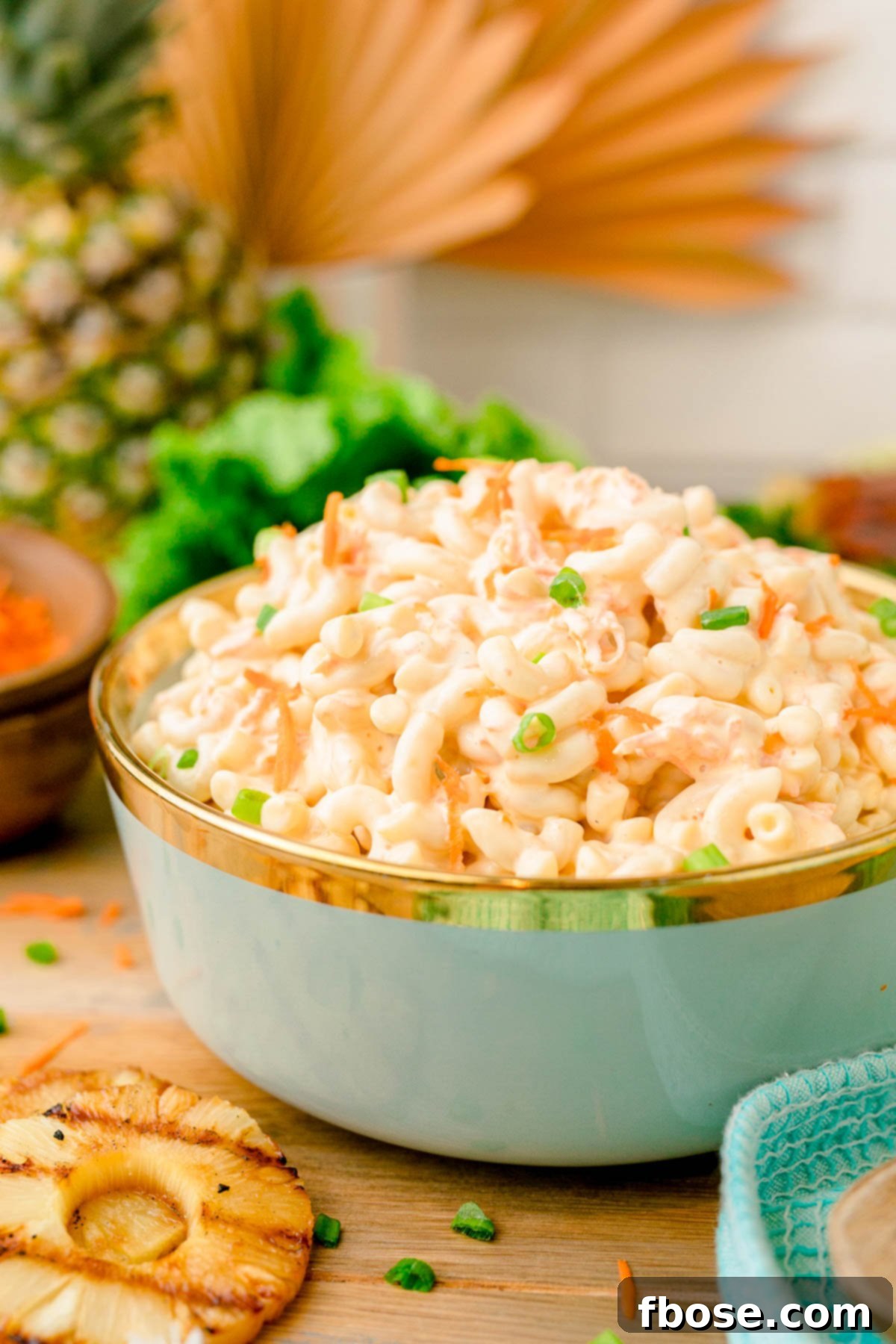 A teal bowl filled with Hawaiian macaroni salad, ready to be served.