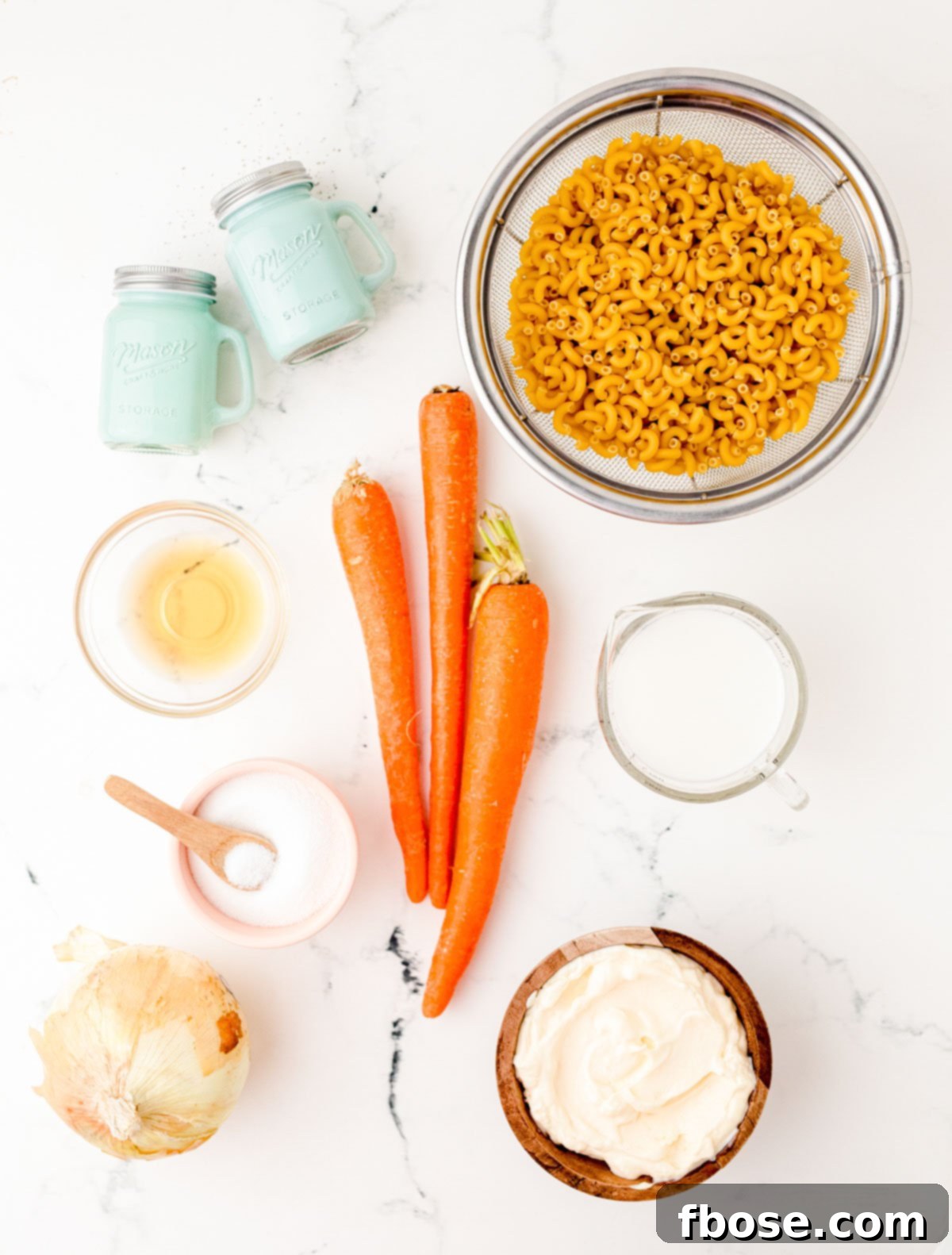 Ingredients to make Hawaiian Macaroni Salad laid out on a marble table.