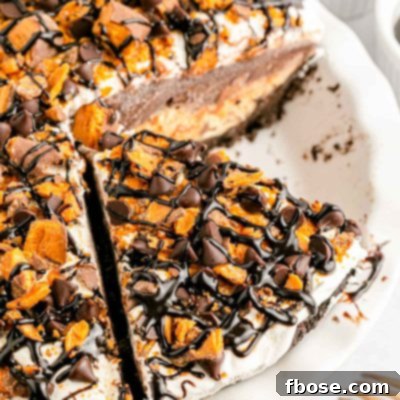 Overhead photo of a no bake butterfinger pie in a white pie dish with a slice missing.