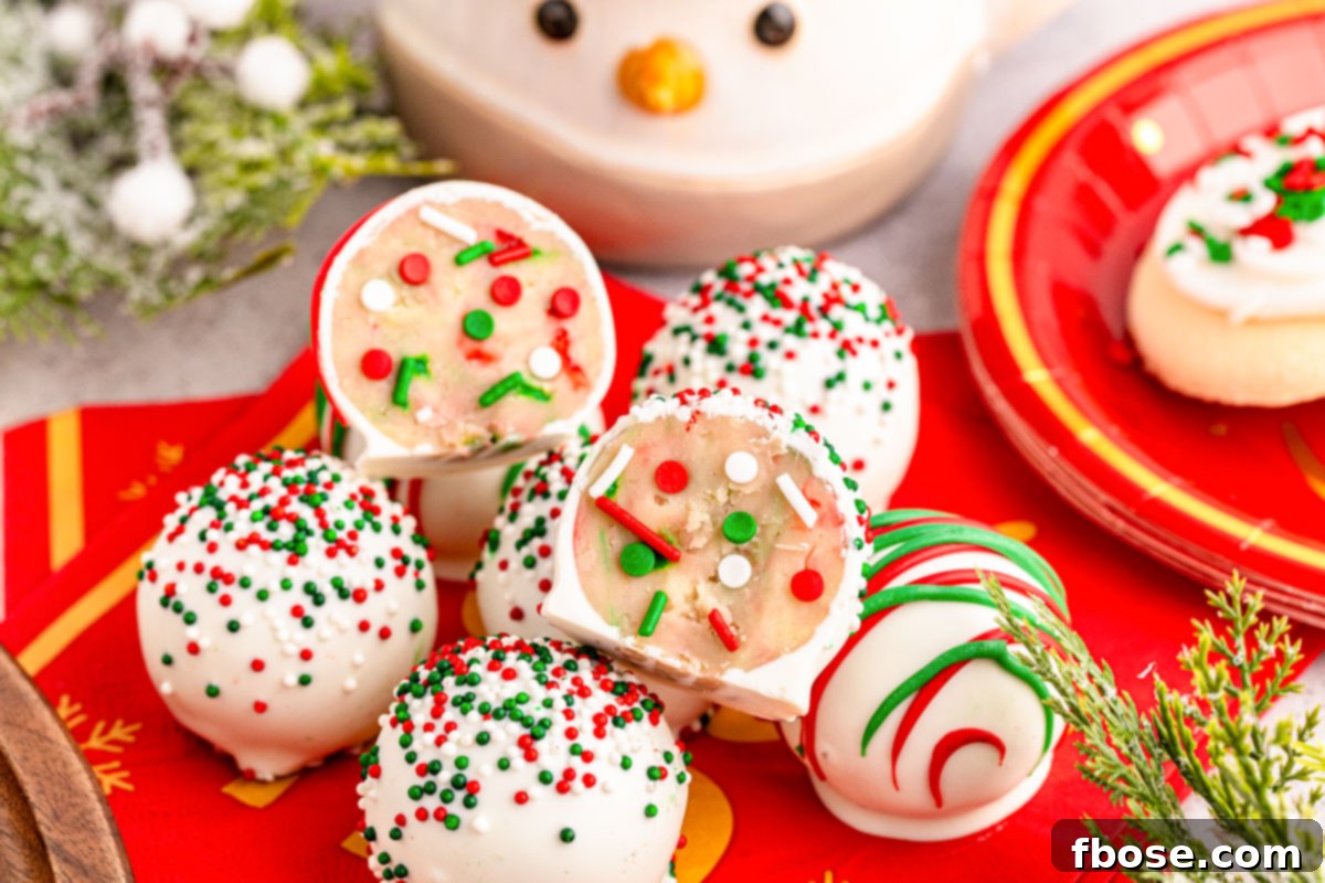 Sugar Cookie truffles on a red plate, one split in half to show the creamy, sprinkle-filled inside.