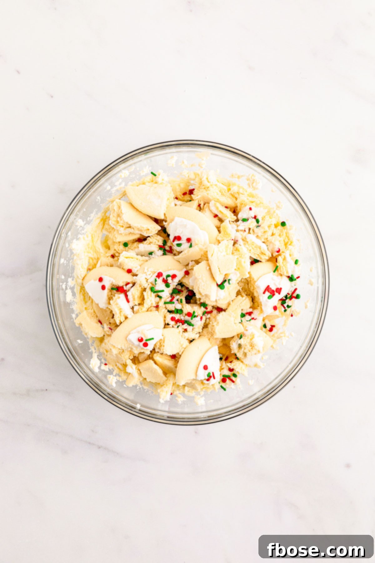 Crumbled Lofthouse cookies in a bowl with softened cream cheese, ready to be mixed.