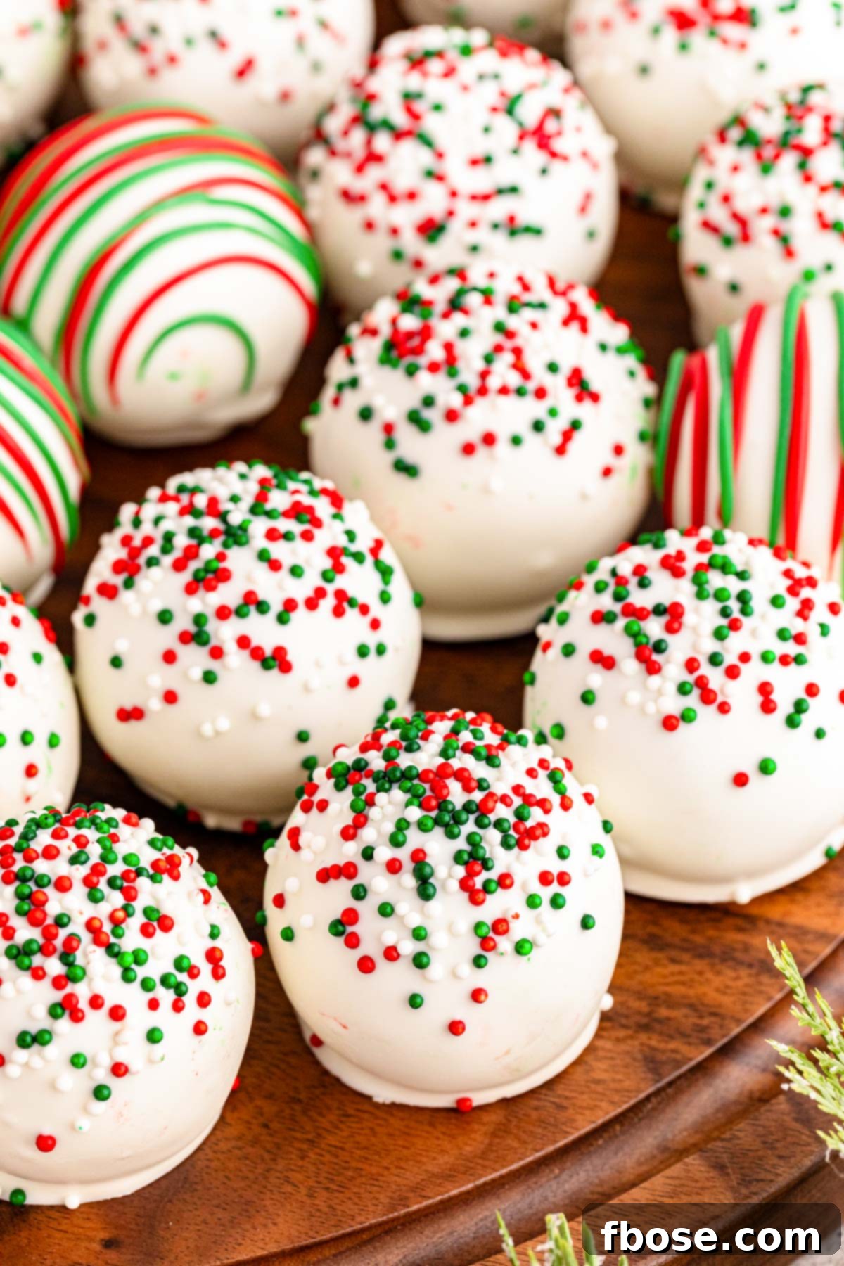 Christmas Cookie Truffles artfully arranged on a rustic wooden platter, adorned with festive foliage.