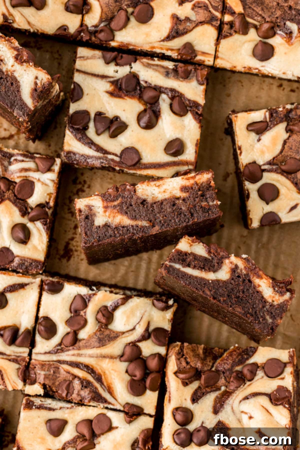 Overhead photo of brownies with cream cheese on a wooden board.