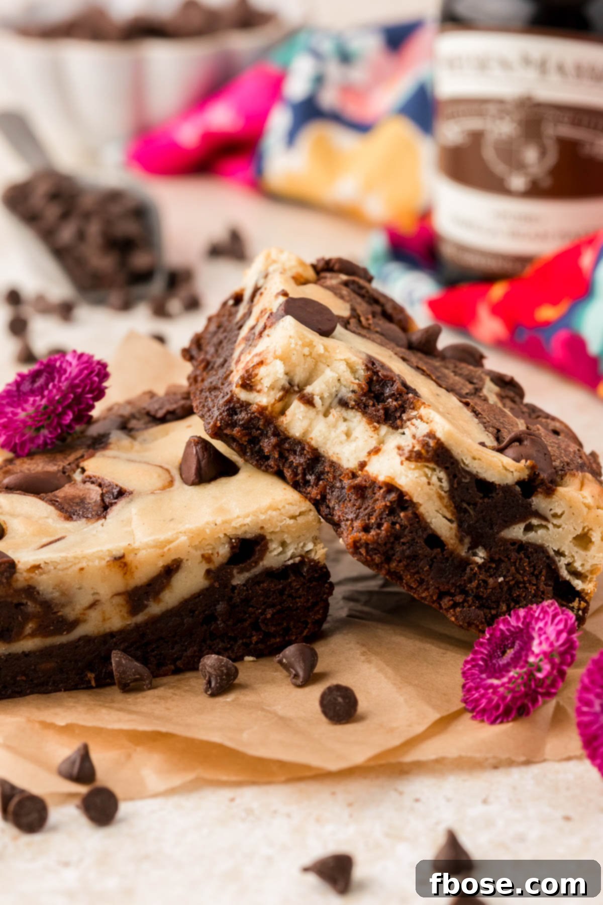 Two cream cheese brownies on a table, one is missing a bite.