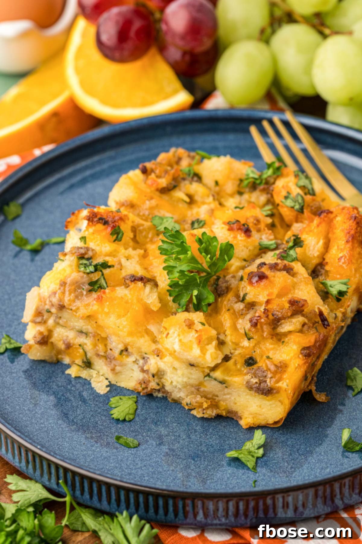 A perfectly portioned slice of golden Sausage Breakfast Strata on a blue plate, ready to be enjoyed.
