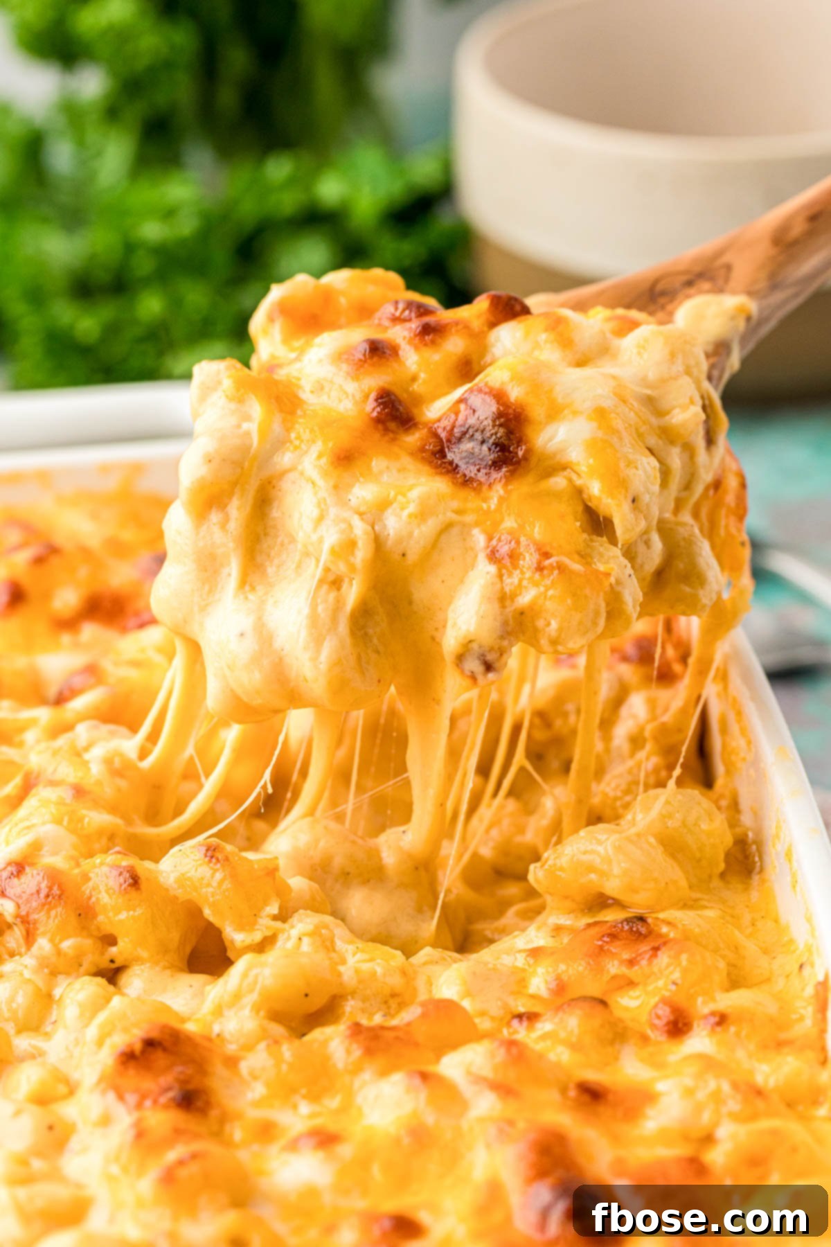 Mac and cheese being scooped out of a pan, showcasing its creamy texture.