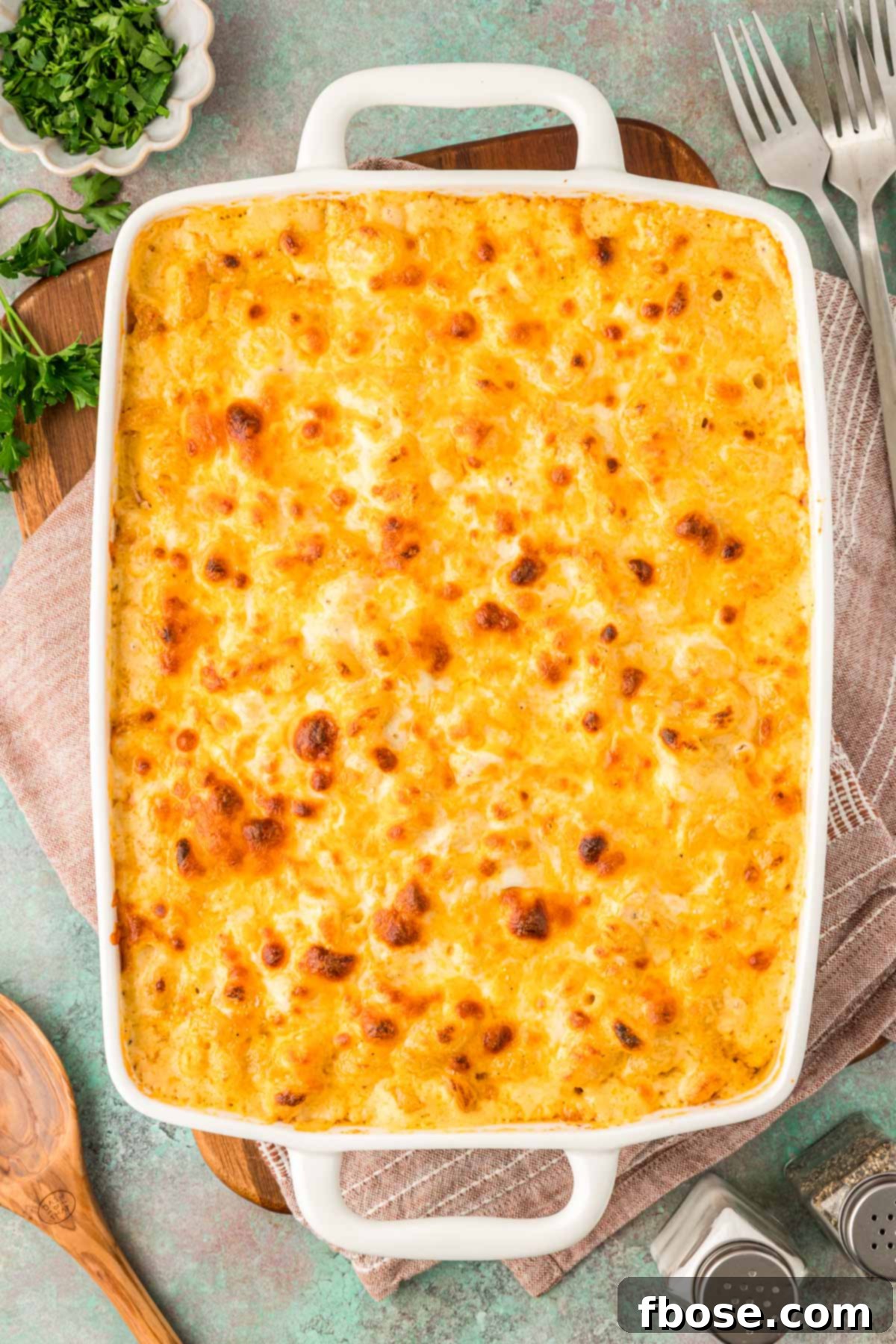 Overhead photo of a casserole dish filled with baked mac and cheese, perfectly golden and bubbly.