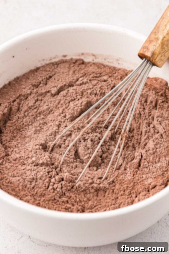 Dry ingredients for chocolate cookies being whisked in a bowl.