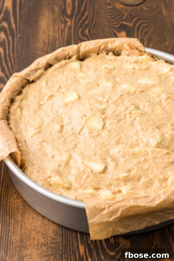 Apple cake batter in a round pan.
