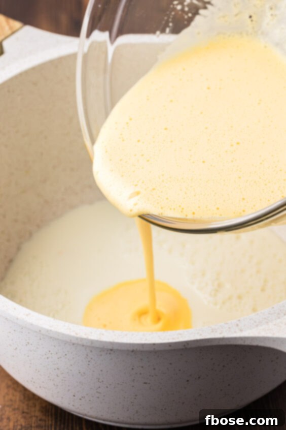 Eggs being whisked into warm milk.