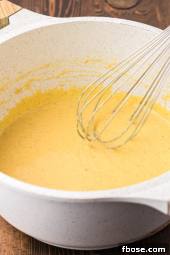 Vanilla custard being whisked in a pot.