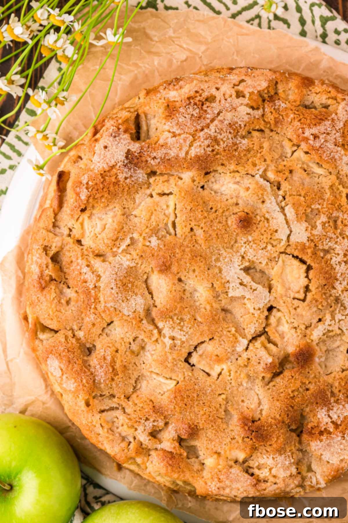 An inviting overhead photo of a whole Irish Apple Cake, beautifully golden, with its rustic, cracked crust visible.