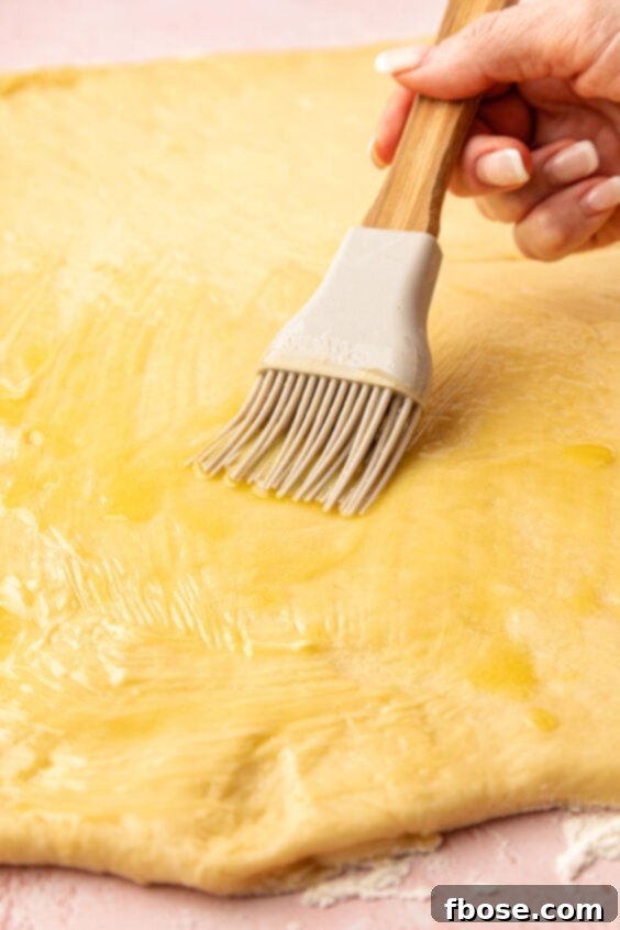 Butter being brushed on dough.