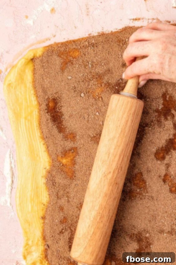A rolling pin roll over cinnamon roll filling.