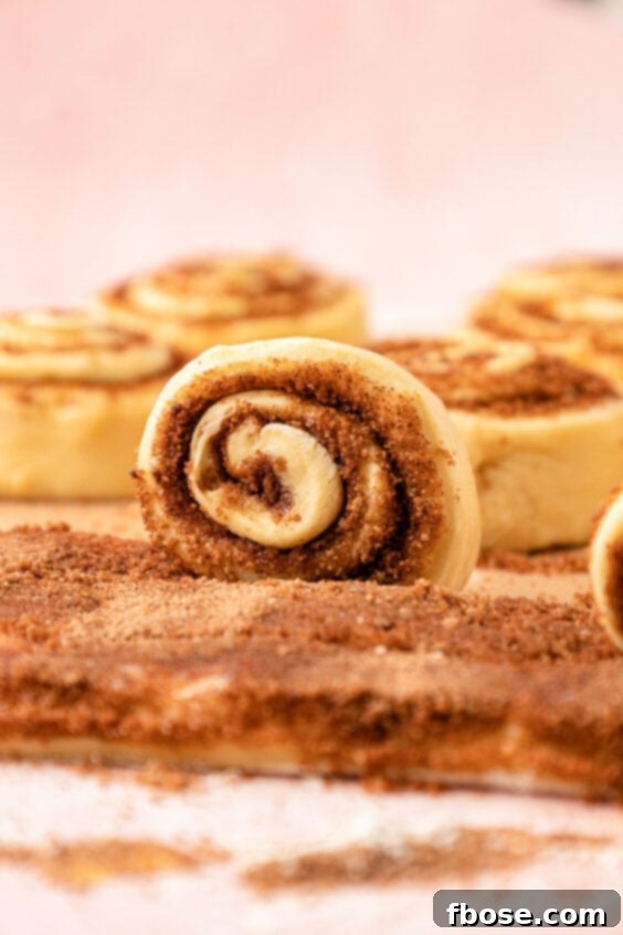 Cinnamon roll strips being rolled up.