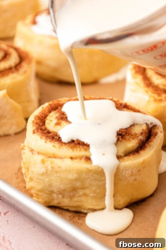 Heavy cream bring poured over cinnamon rolls.
