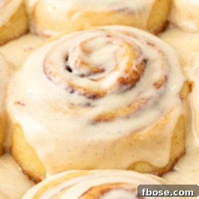 Close up of iced cinnamon rolls on a pan.