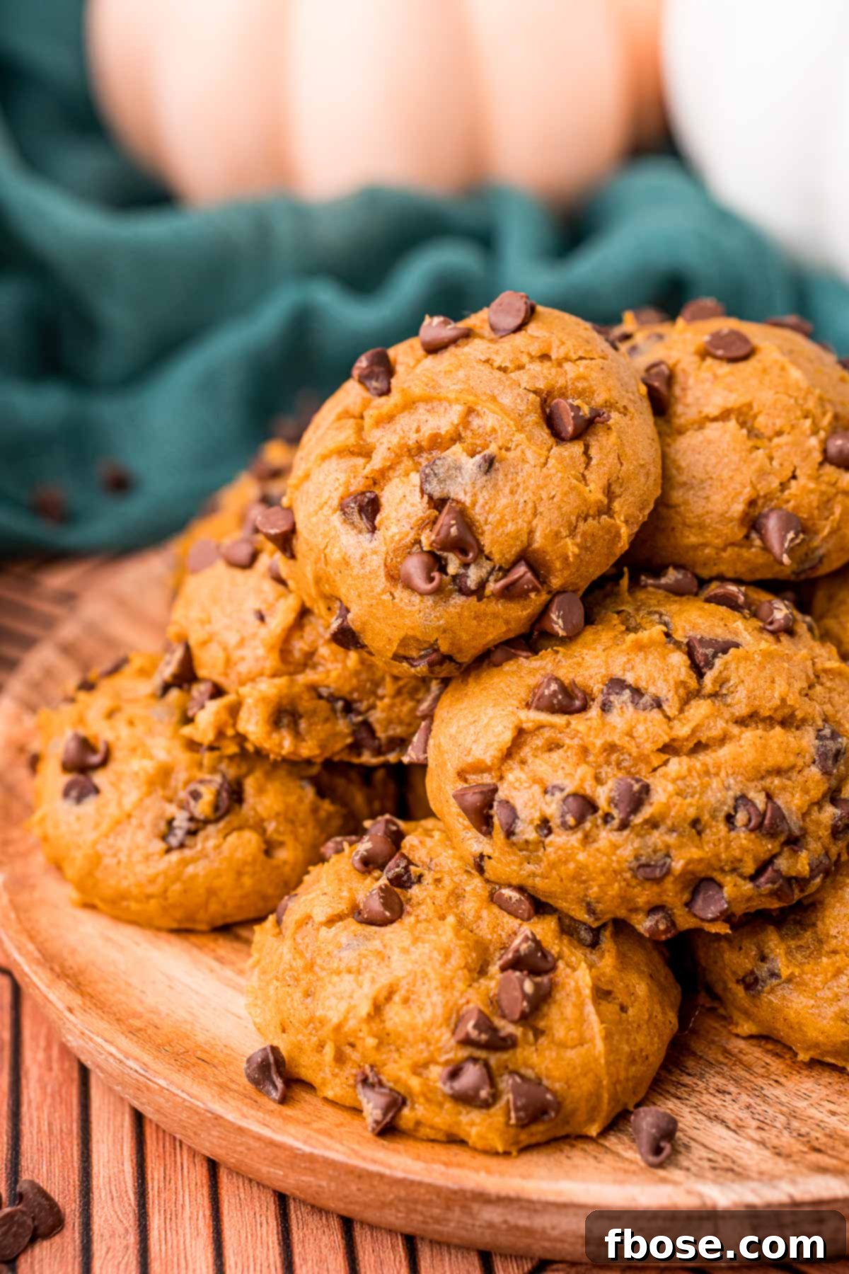 Pumpkin chocolate chip cookies on a wooden plate.