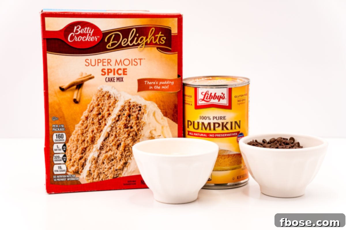 Ingredients to make pumpkin chocolate chip cookies from a cake mix on a white table.