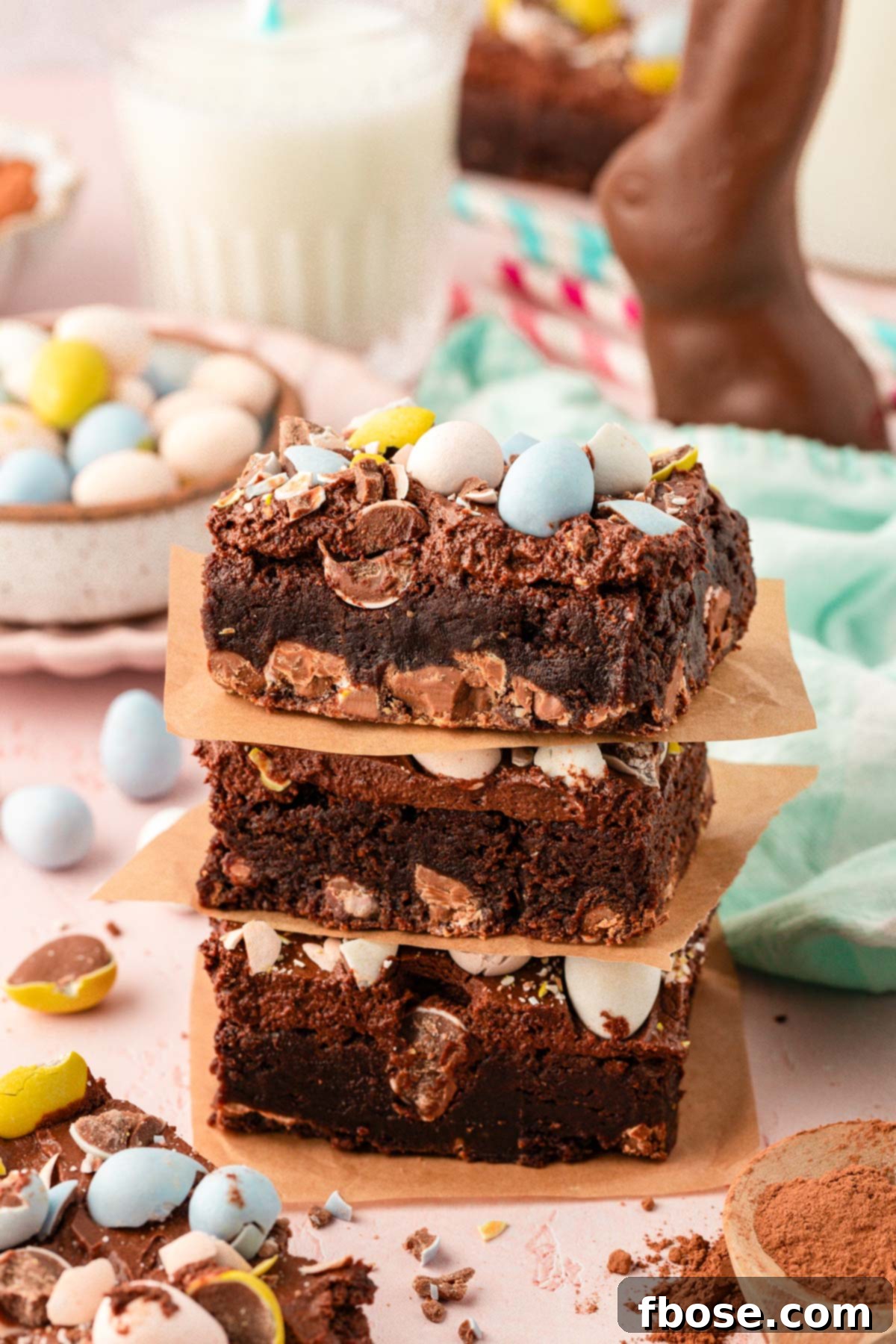Molten Cadbury Egg Brownies 2 Close up of a stack of three Cadbury Egg Brownies, showcasing their fudgy texture and colorful candy topping.