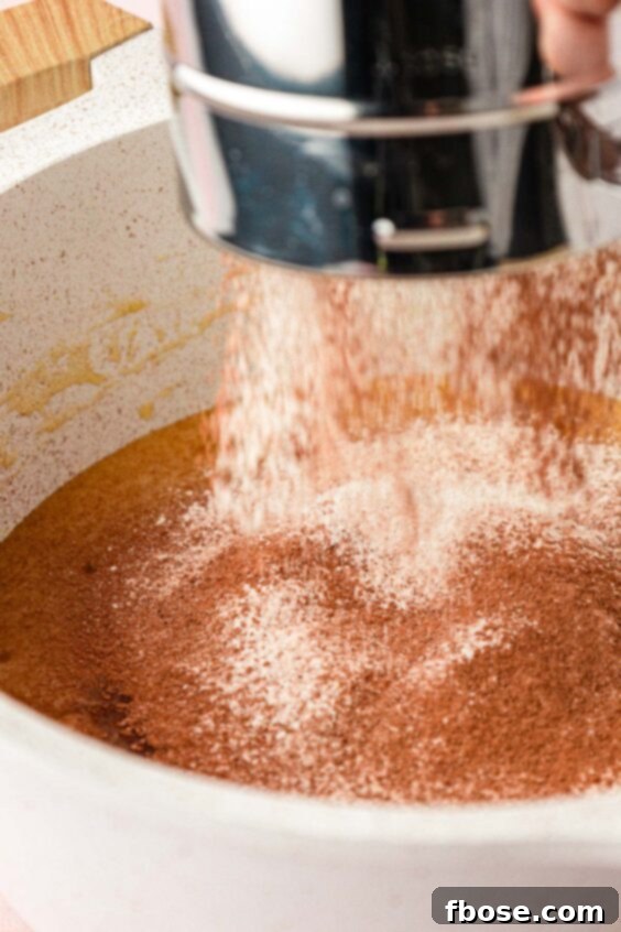 Molten Cadbury Egg Brownies 14 Dry ingredients being sifted into wet ingredients to make brownie batter.