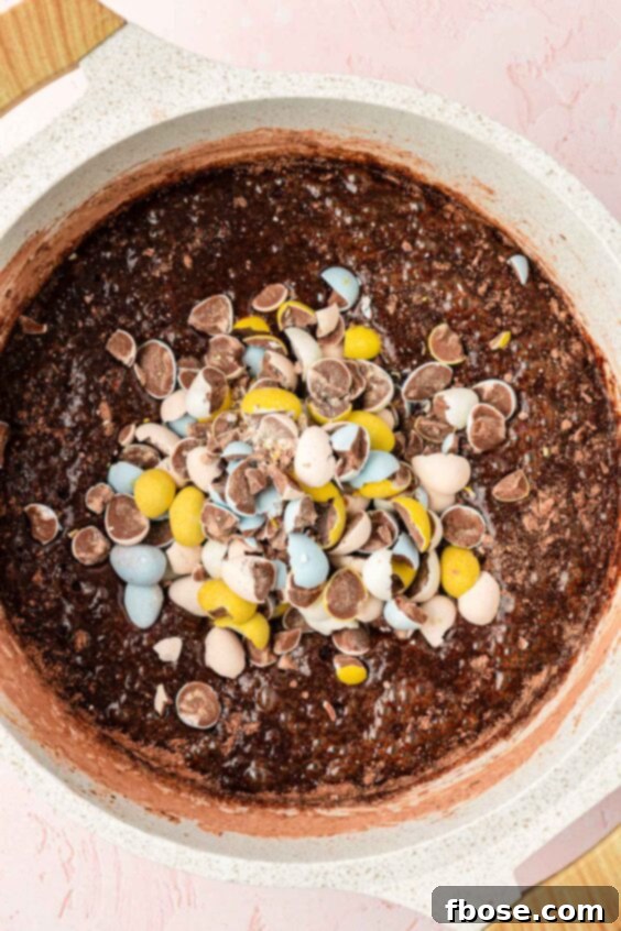 Molten Cadbury Egg Brownies 17 Cadbury mini eggs being added to brownie batter.