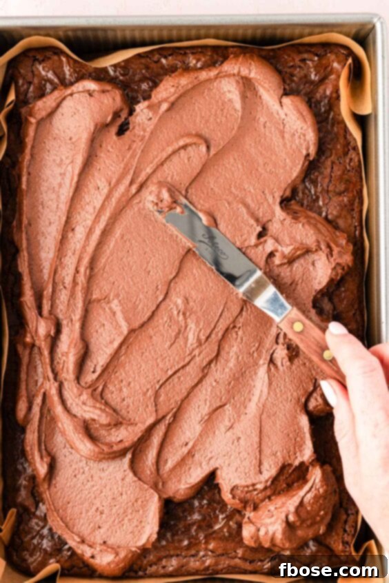 Molten Cadbury Egg Brownies 21 Frosting being spread over the top of brownies.